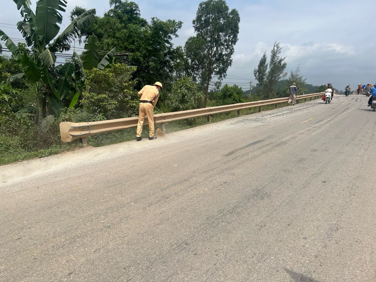 Hình ảnh đẹp của các chiến sĩ CSGT-TT Công an huyện Nghi Lộc thu dọn bê tông tươi rơi vãi trên đường được người dân ghi lại