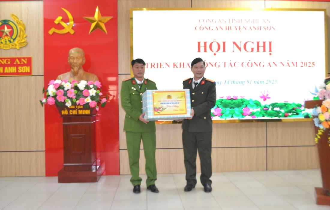 Đồng chí Đại tá Lê Văn Thái - Phó Giám đốc Công an tỉnh trao quà của đồng chí Giám đốc Công an tỉnh tặng Công an huyện Anh Sơn 