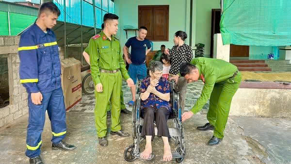 Cụ bà Võ Thị Phương (trú tại xã Nghi Xá) xúc động khi nhận xe lăn và quà tặng từ đoàn hỗ trợ