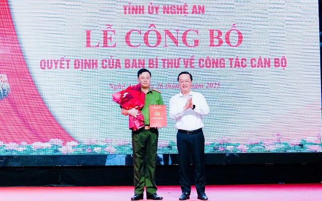 Đồng chí Nguyễn Đức Trung, Bí thư Tỉnh ủy đã trao quyết định của Ban Bí thư Trung ương Đảng, tặng hoam, chúc mừng đồng chí Đại tá Đinh Việt Dũng - Ủy viên Ban Thường vụ Tỉnh ủy, Giám đốc Công an tỉnh Nghệ An
