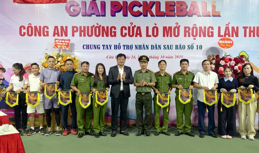 Đồng chí Ngô Đức Kiên - Bí thư Đảng ủy, Chủ tịch HĐND phường Cửa Lò và đại diện Lãnh đạo Phòng Công tác chính trị Công an tỉnh tặng cờ lưu niệm cho các đội tham gia thi đấu