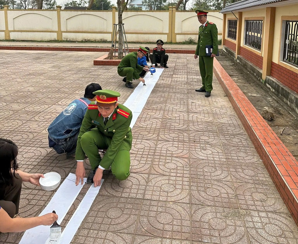 Công an xã phối hợp Đoàn xã sơn kẻ các ô vị trí, vạch dừng đỗ dành riêng cho xe của phụ huynh