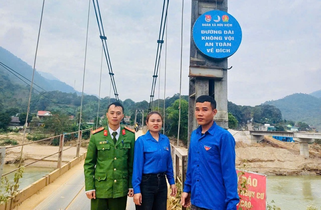 Cán bộ Công an xã Hữu Kiệm phối hợp với Đoàn Thanh niên xã tiến hành treo, lắp đặt biển tại khu vực cầu treo