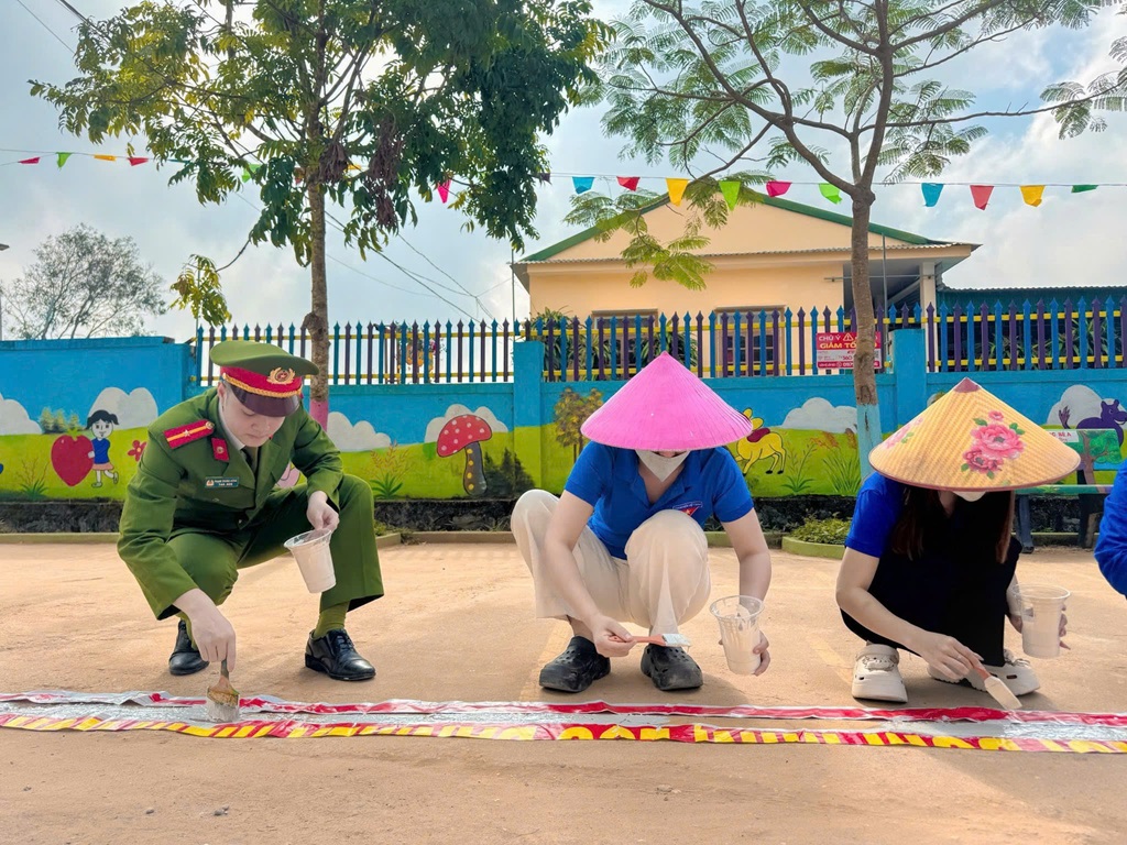 Công an xã Nghĩa Đồng phối hợp Đoàn xã kẻ vạch phân làn dừng, đỗ xe trước cổng trường