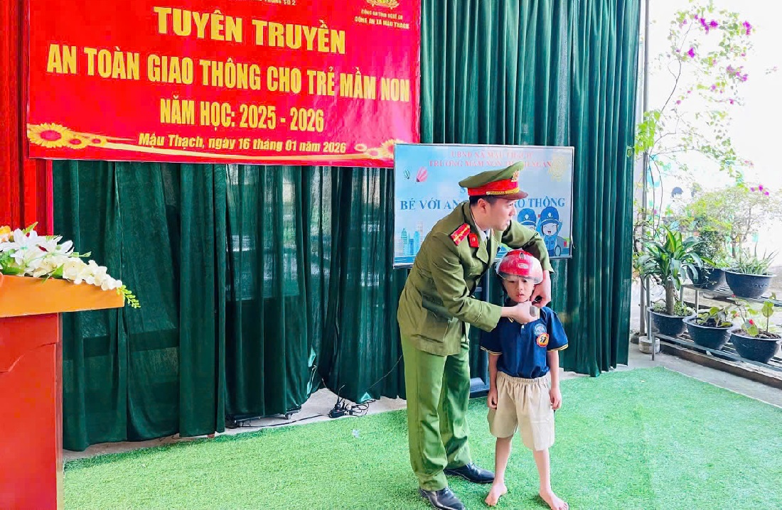 Cán bộ Công an hướng dẫn trẻ em đội mũ bảo hiểm đúng quy cách
