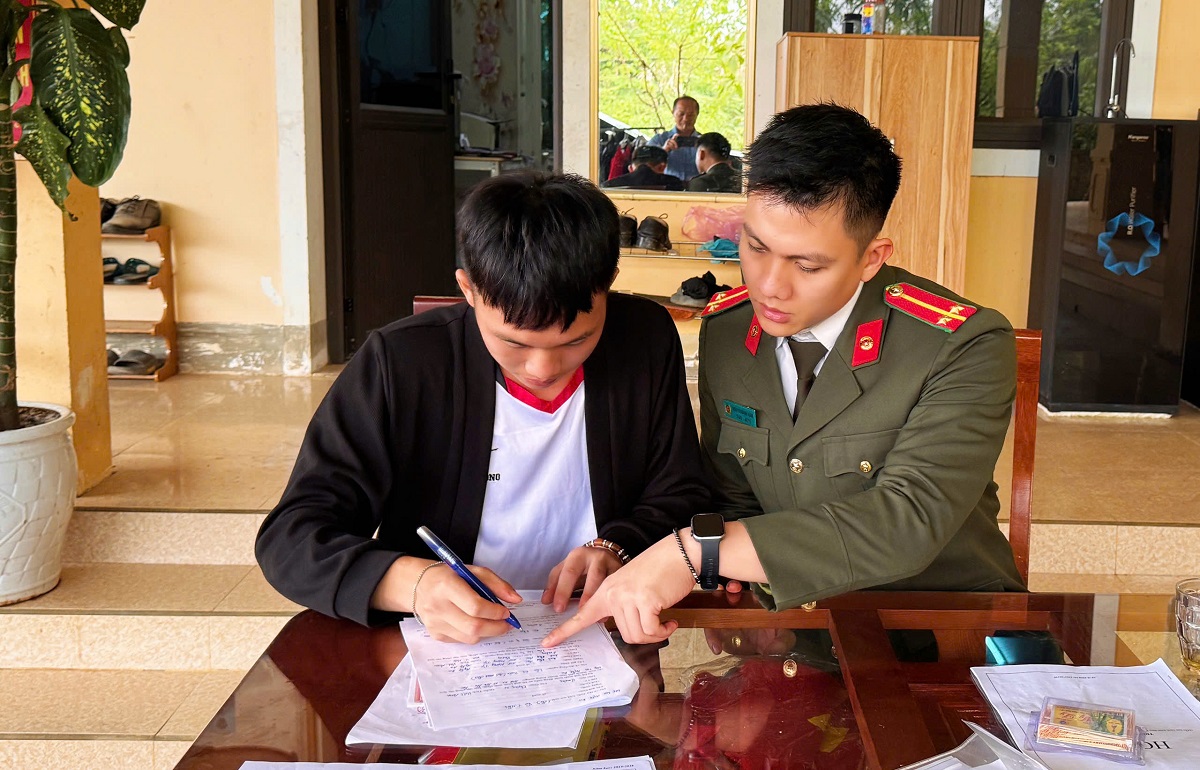 Cán bộ Công an xã Na Ngoi hướng dẫn công dân thủ tục đăng ký dự tuyển