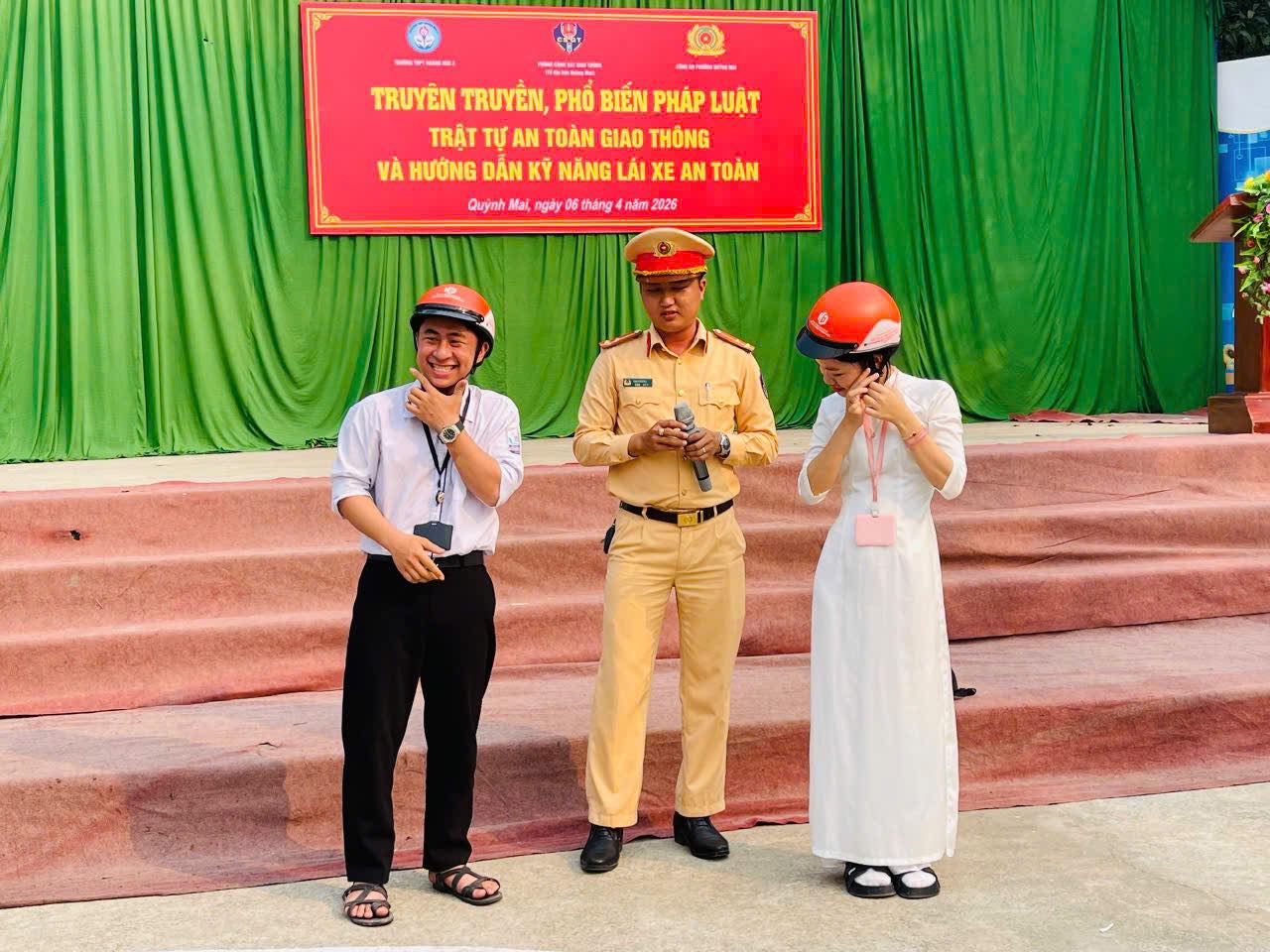 Cảnh sát giao thông hướng dẫn học sinh đội mũ bảo hiểm đúng cách