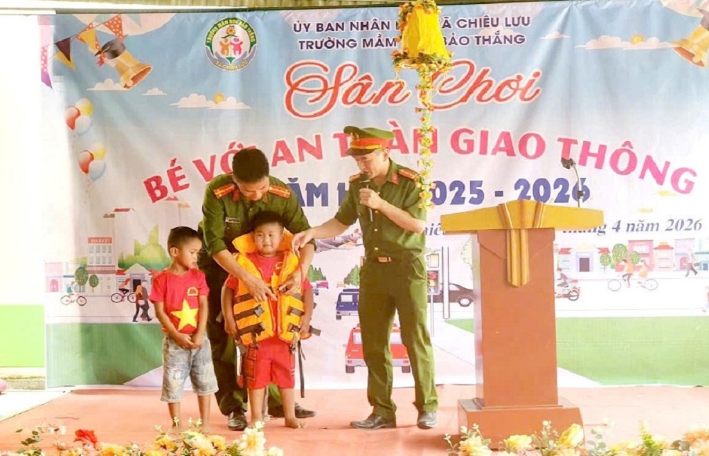 Công an xã Chiêu Lưu hướng dẫn trẻ  đội mũ bảo hiểm đúng quy cách và mang áo phao an toàn 