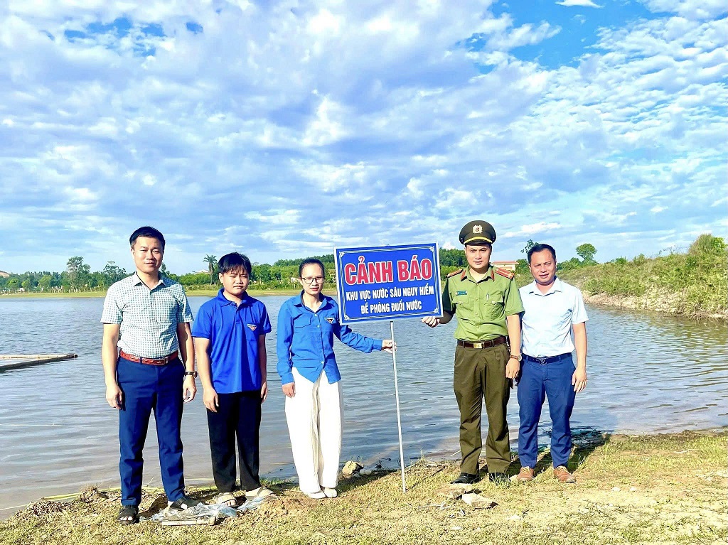 ông an xã Quỳnh Tam phối hợp lắp đặt biển cảnh báo phòng, chống đuối nước