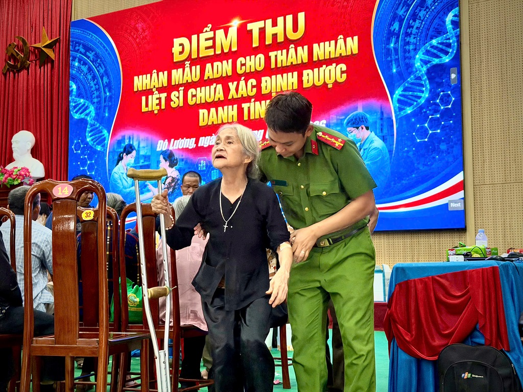 Công an xã Anh Sơn hỗ trợ thân nhân liệt sĩ đến điểm thu nhận mẫu sinh phẩm ADN