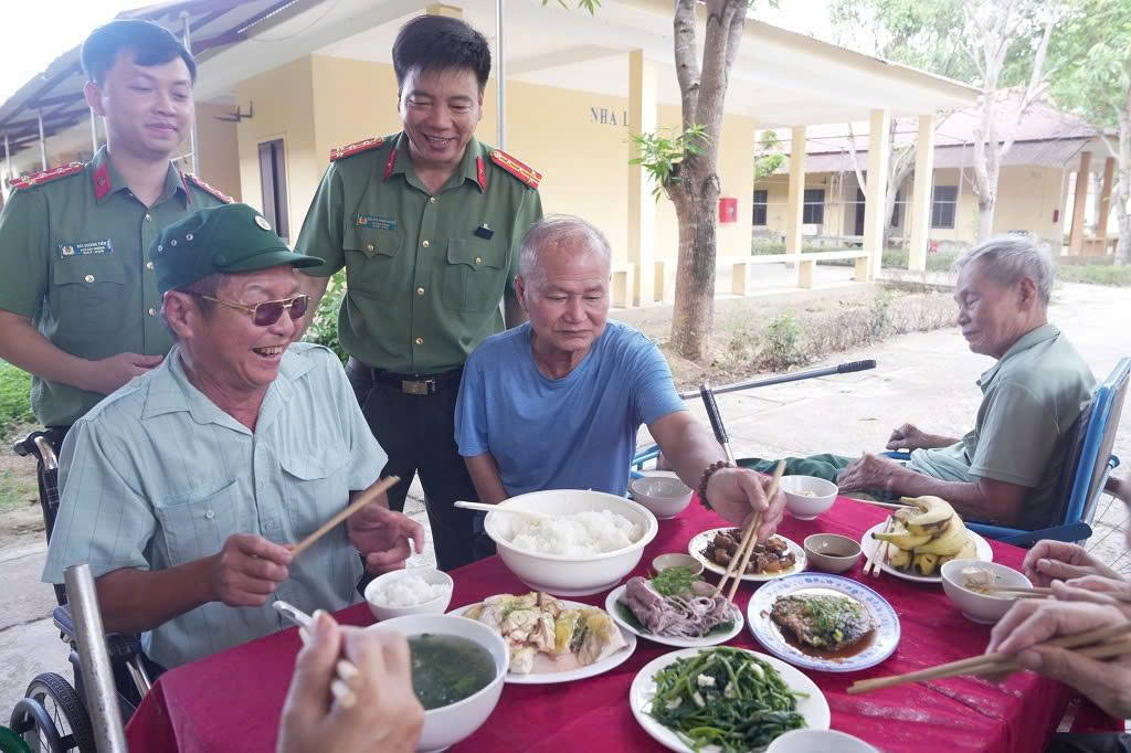 Lãnh đạo, cán bộ, chiến sĩ Phòng Công tác chính trị và Phòng Hậu cần Công an tỉnh và cán bộ Trung tâm Điều dưỡng Thương binh Nghệ An chuẩn bị bữa cơm thân mật cho thương, bệnh binh và người có công với cách mạng