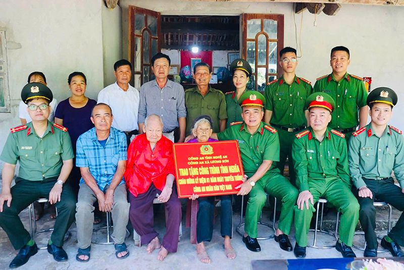 ông an xã trao công trình đến cụ bà Trần Thị Huệ