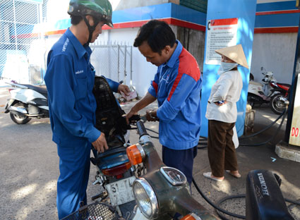 Từ ngày 6-12, giá xăng tiếp tục giảm 312 đồng/lit. Trong ảnh: Khách hàng đổ xăng theo giá mới.