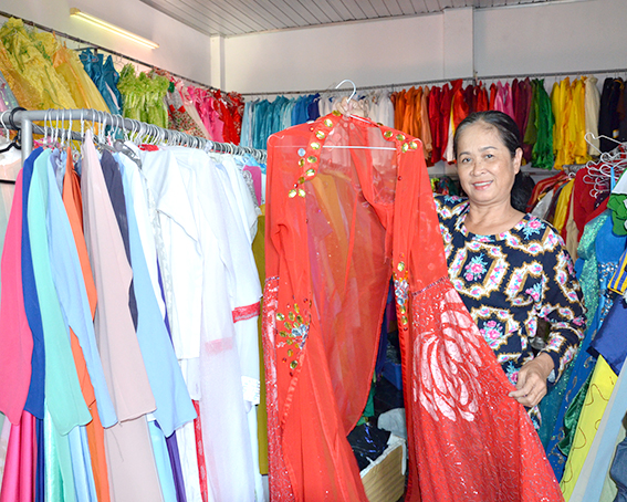 Chị Kim Anh giới thiệu mẫu trang phục cho thuê được nhiều khách ưa chuộng.