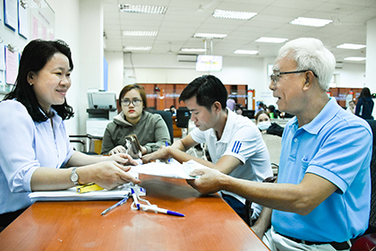 Chị Nguyễn Thị Bé, cán bộ Bộ phận tiếp nhận và trả kết quả tập trung cấp tỉnh, hướng dẫn ông Trần Văn Khôi (SN 1952, ngụ tại 412/14 Lê Hồng Phong, TP. Vũng Tàu) các thủ tục đăng ký đổi giấy phép lái xe. Ảnh: PHÚC LƯU 