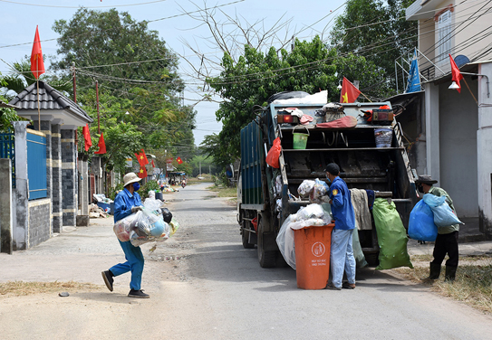 Công nhân Công ty CP Dịch vụ Đô thị Tân Thành thu gom rác trên địa bàn. 