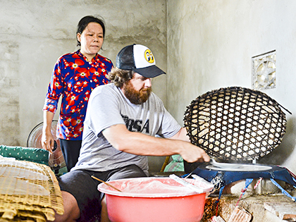 Anh James Cuthbertson - du khách người Mỹ trải nghiệm tráng bánh tại nhà bà Nguyễn Thị Bông (xã Long Phước, TP. Bà Rịa) trong hành trình khám phá văn hóa ẩm thực Việt do City tour tổ chức. Ảnh: THANH NGA