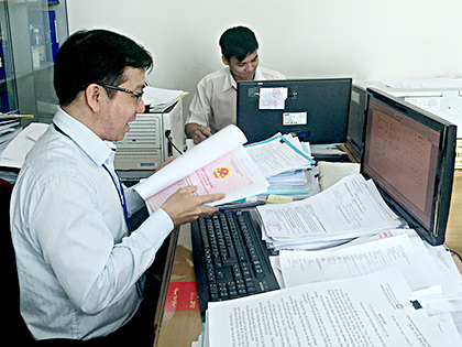 Cán bộ Văn phòng đăng ký đất đai một cấp giải quyết hồ sơ cho hộ gia đình, cá nhân từ tuyến huyện chuyển về.
