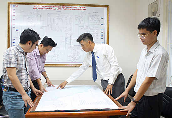 Anh Bùi Tiến Hùng (bìa phải) và kỹ sư Nguyễn Đình Phong (thứ 2 từ phải sang) cùng các cộng sự trao đổi giải pháp kỹ thuật tại công ty.