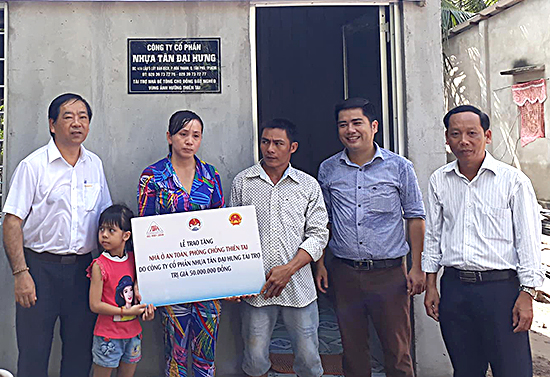 Ông Tạ Ngọc Tân, đại diện Tổng cục Phòng chống thiên tai (thứ 2 từ phải qua) và ông Nguyễn Võ Khoa, Phó Tổng Giám đốc Busadco (ngoài cùng bên trái) trao nhà cho gia đình ông Lê Văn Tấn (tỉnh Bến Tre). Ảnh: HOÀI THU