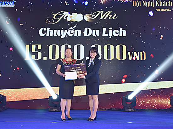 Bà Huỳnh Phan Phương Hoàng, Phó Tổng Giám đốc Vietravel trao phiếu trúng thưởng là chuyến du lịch trị giá 15 triệu đồng cho khách hàng may mắn.