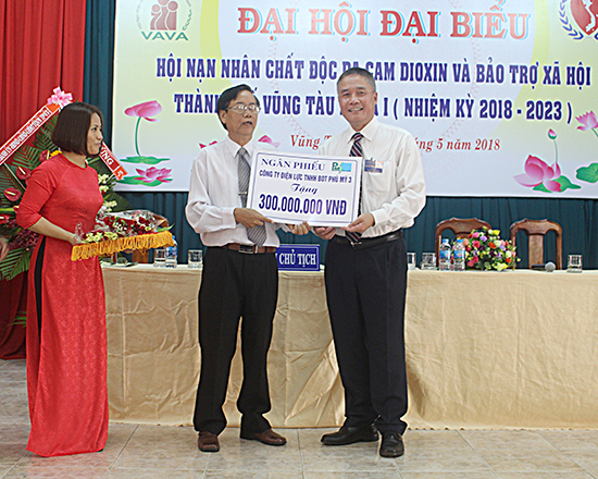 Ông Đỗ Bá Cảnh (bìa phải), Tổng Giám đốc Công ty Điện lực TNHH BOT Phú Mỹ 3 tặng ngân phiếu ủng hộ cho Hội Nạn nhân chất độc da cam Dioxin và Bảo trợ xã hội TP.Vũng Tàu.