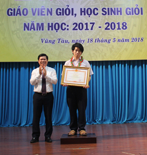Đồng chí Nguyễn Văn Xinh, Ủy viên Ban Thường vụ Tỉnh ủy, Trưởng Ban Tuyên giáo Tỉnh ủy trao Bằng khen của Thủ tướng Chính phủ cho em Hoàng Hữu Quốc Huy, cựu HS Trường THPT Chuyên Lê Quý Đôn.