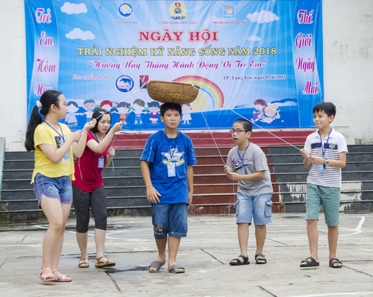 Các em thiếu nhi tham gia trò chơi vận động “Cùng bạn truyền bóng”.