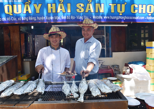 Nhân viên quầy hải sản tự chọn tại Hương Phong-Hồ Cốc Beach Resort nướng cá phục vụ khách tại chỗ.
