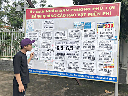 Người dân tìm kiếm thông tin trên bảng quảng cáo, rao vặt miễn phí tại phường Phú Lợi, TP. Thủ Dầu Một.