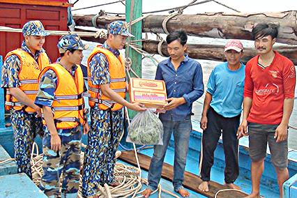 Cán bộ, chiến sĩ tàu 9001 tặng quà cho ngư dân làm việc trên tàu cá BĐ 98271TS.
