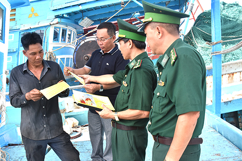 Lực lượng Biên phòng phát tờ rơi tuyên truyền cho thuyền trưởng tàu cá ở phường 5 (TP. Vũng Tàu) chấp hành các quy định trong quá trình đánh bắt.