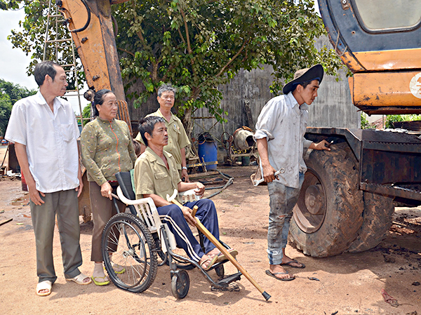 Thương binh Trịnh Đức Khuyến (ngồi xe lăn), dù hay đau bệnh do vết thương cũ tái phát nhưng luôn theo sát việc kinh doanh, làm ăn của gia đình.