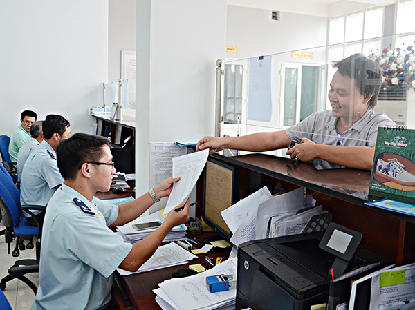 Cán bộ Chi cục Hải quan Phú Mỹ hướng dẫn DN thực hiện các thủ tục hải quan. Ảnh: TRÀ NGÂN