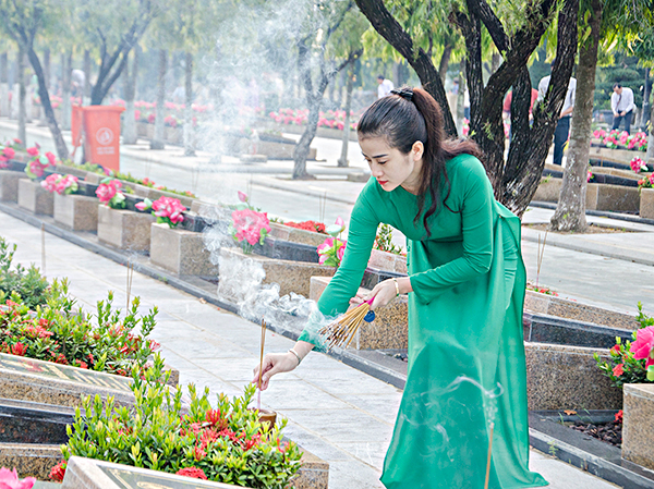 Người dân thắp nhang trên các phần mộ liệt sĩ.