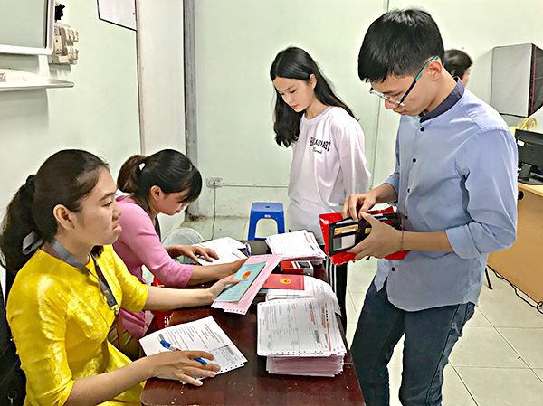 Nhân viên Bưu điện tỉnh tư vấn cho người dân gửi hồ sơ về tận nhà sau khi làm CMND.