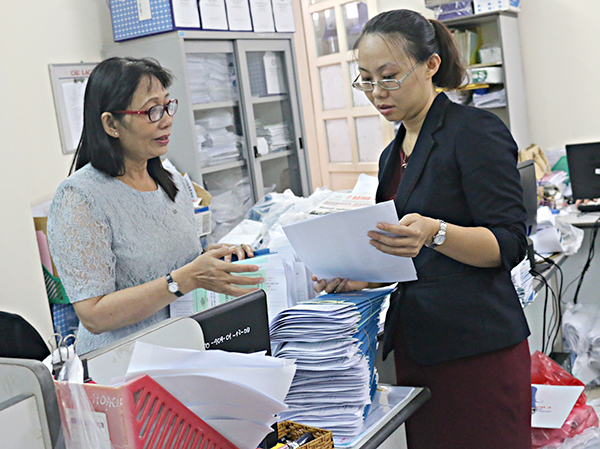 Cán bộ BHXH tỉnh hướng dẫn đơn vị sử dụng lao động bàn giao sổ BHXH cho NLĐ.