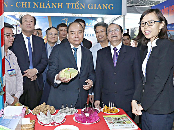 Thủ tướng thăm các gian hàng trưng bày sản phẩm của DN đầu tư tại Tiền Giang. Ảnh: QUANG HIẾU