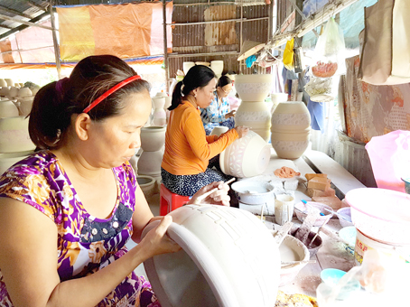 Thợ chấm men làm việc tại Cơ sở gốm Thanh Loan.
