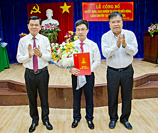 Các đồng chí: Nguyễn Hồng Lĩnh, Ủy viên Trung ương Đảng, Bí thư Tỉnh ủy, Chủ tịch HĐND tỉnh; Nguyễn Văn Trình, Phó Bí thư Tỉnh ủy, Chủ tịch UBND tỉnh trao quyết định và tặng hoa chúc mừng đồng chí Đặng Minh Thông, Tỉnh ủy viên, Phó Chủ tịch UBND tỉnh đến nhận công tác tại Thành ủy Bà Rịa.