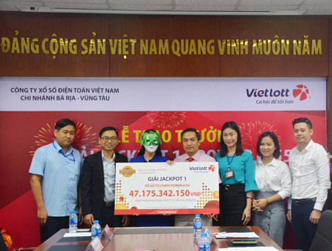 Đại diện Vietlott Chi nhánh BR-VT trao giải cho bà Đ.T.T.H. (người đeo mặt nạ).