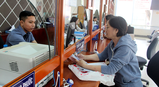 Cải cách thủ tục hành chính là một trong những giải pháp nhằm thúc đẩy sự phát triển của các DN.  Trong ảnh: Cán bộ bộ phận một cửa UBND huyện Long Điền tiếp nhận hồ sơ  của người dân, DN.