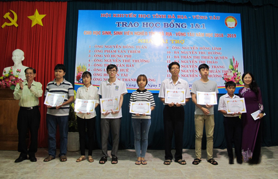 Đại diện Hội Khuyến học tỉnh và nhà tài trợ trao học bổng 1+1 cho HS-SV nghèo năm học 2018-2019.
