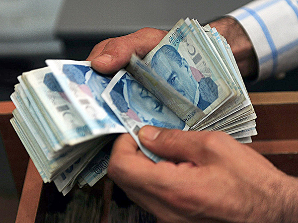 Một nhân viên văn phòng trao đổi tính tiền giấy lira Thổ Nhĩ Kỳ ở Istanbul. 