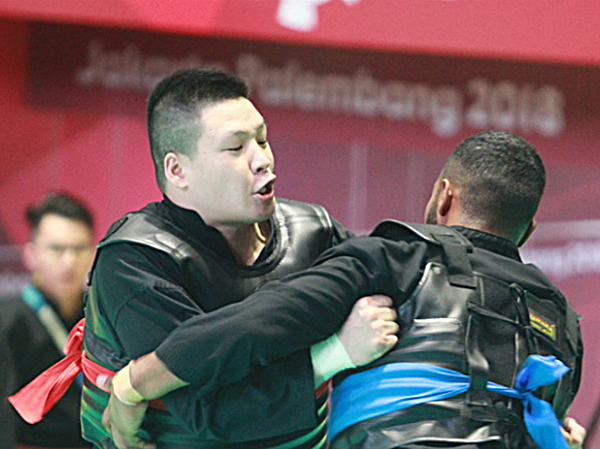  Văn Trí (trái) vào chung kết hạng cân nặng nhất trong pencak silat.