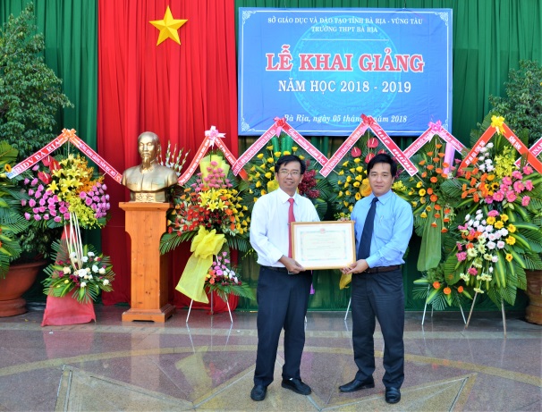 Đồng chí Dương Minh Tuấn, Phó Trưởng Đoàn ĐBQH tỉnh trao quyết định khen thưởng “Tập thể lao động tiên tiến” của Sở GD-ĐT cho thầy Nghiêm Văn Giang, Hiệu trưởng Trường THPT Bà Rịa. Ảnh: Đinh Hùng