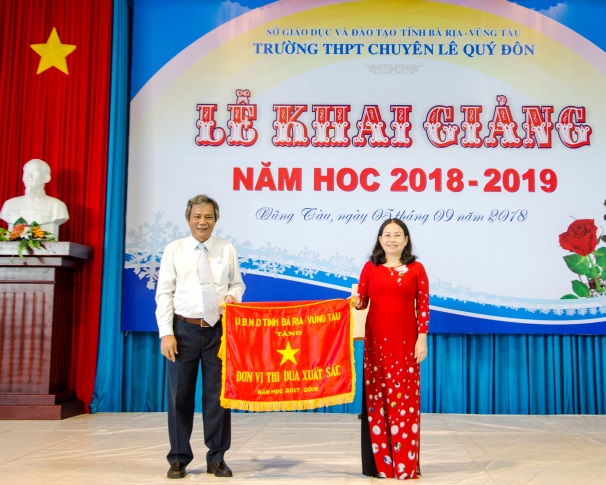 Đồng chí Nguyễn Thị Yến, Phó Bí thư Thường trực Tỉnh ủy, Trưởng Đoàn ĐBQH tỉnh trao Cờ Thi đua của UBND tỉnh cho Trường THPT Chuyên Lê Quý Đôn. Ảnh: Mạnh Thắng