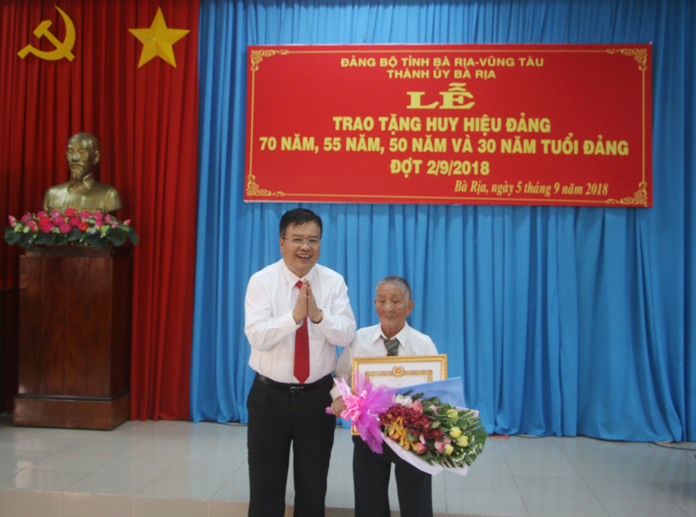 Đồng chí Nguyễn Văn Trình, Phó Bí thư Tỉnh ủy, Chủ tịch UBND tỉnh trao Huy hiệu 70 năm tuổi Đảng cho đồng chí Phan Viết Thành (sinh hoạt tại Chi bộ khu phố 4, Đảng bộ phường Phước Nguyên, TP.Bà Rịa). 