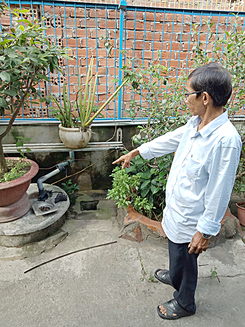 Ông Phan Văn Hóa bên giếng nước khoan của gia đình.   