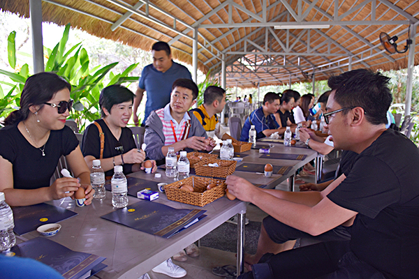 Một nhóm khách Trung Quốc thưởng thức trứng gà luộc từ nguồn nước nóng tự nhiên của KDL Sài Gòn-Bình Châu.